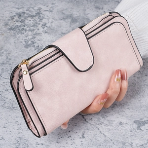 Detailed view of long pink matte leather wallet with zipper pocket and snap closure detail
