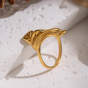 Macro shot of gold petal ring with irregular fluid texture on a white stone pedestal