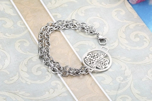 Detail view of double-layer silver hand of fatima bracelet with delicate hollow design