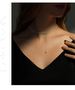 Detail of s925 silver star pendant necklace on model with dramatic side lighting