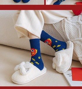 Détail de chaussettes tricotées bleu marine avec chaussons en peluche à nœud blanc