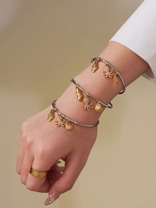 Detailed shot of octopus and seashell charms on silver bangles with star ring