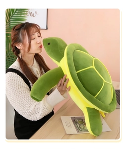 Detailed view of giant green sea turtle plush toy held by a woman in a cozy home setting