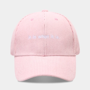 Dettaglio cappello da baseball in velluto rosa con ricamo del testo it is what it is