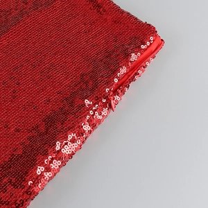 Detail of red sequin fabric featuring high-density shimmer and a matching hidden zipper