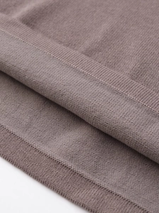Detail of taupe soft-knit straight skirt featuring ribbed edges and high-quality texture