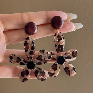 Detail showing resin flower earrings with leopard print and vintage brown tones