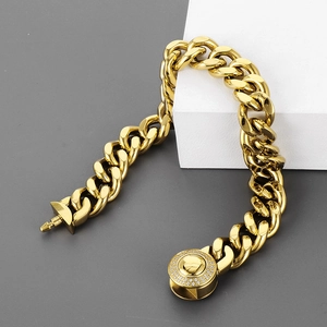 Detailed close-up of golden Cuban link necklace with diamond-encrusted circular buckle