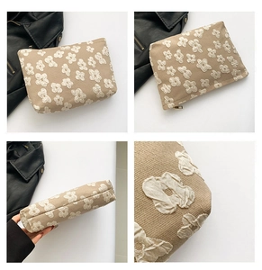 Close-up of beige linen bag with 3D floral embroidery and smooth zipper detail