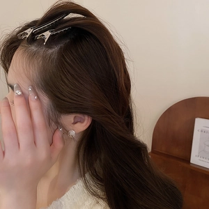 Vue détaillée de deux pinces à cheveux minimalistes en métal argenté sur cheveux bruns