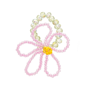 Handmade pink glass bead flower ring with yellow core and iridescent crystals on white background