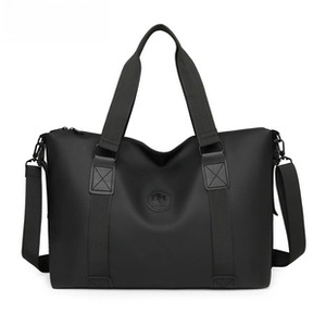 Close-up of matte black waterproof travel bag featuring cross-stitching and embossed logo