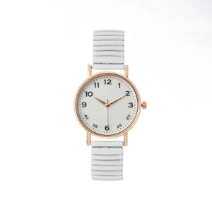 Détail de la montre ronde or rose avec bracelet blanc ondulé et chiffres clairs