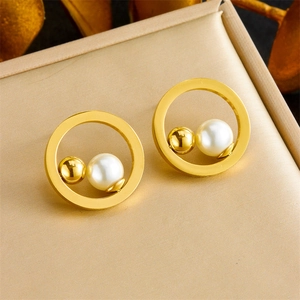 Minimalist geometric hollow gold earrings with white pearl detail on display pad