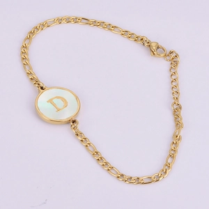 Macro shot of 18K gold chain bracelet featuring a shell inlay letter D pendant charm