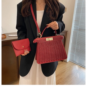 Close-up of red woven texture handbag with gold hardware and matching card wallet