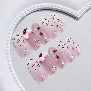 Handmade press-on nails with leopard print and pink bow accents on a mirror tray