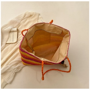Detailed interior of a colorful woven beach tote bag with beige lining and zip pocket