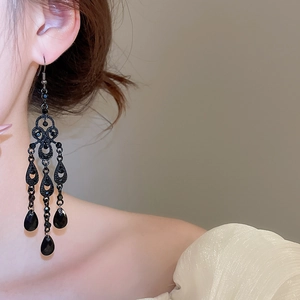 Close-up of black teardrop chandelier earrings worn by a model in vintage gothic style