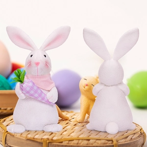 Detail of bunny figurines with checkered carrot and pink scarf on a woven tray