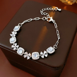 Vue macro d'un bracelet fleur en argent et zircon sur un coffret en cuir chic