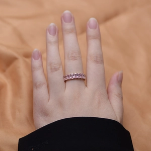 Detail of gold-plated silver ring with pink rectangular-cut zircons on a model's finger
