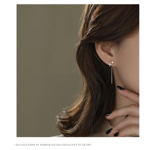Detailed close-up of S925 silver star tassel earrings worn on ear showing fine chain drop