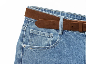 Close-up of high-waisted wide-leg denim jeans with a brown matte belt and pocket detail