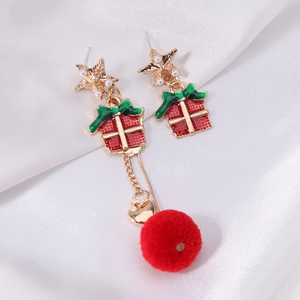 Detail of festive Christmas earrings with star, red gift box and soft pompom pendant