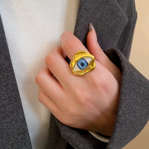 Nahaufnahme des goldfarbenen Evil-Eye-Rings im Vintage-Stil an der Hand