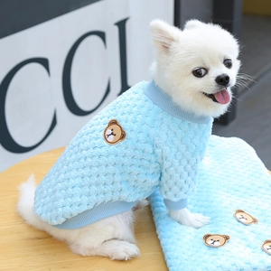 Dettaglio del maglione celeste per animali con ricamo a orsetto e trama a rilievo