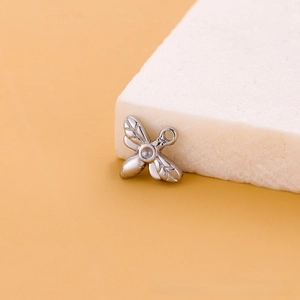 Détail d'un pendentif abeille en acier inoxydable sur pierre pour création de bijoux DIY