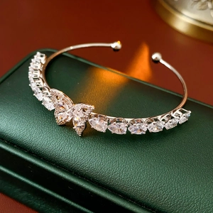 Vue macro d'un bracelet fleur en zircon argenté sur une boîte en cuir vert chic