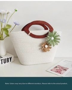 Detail of woven cotton rope bag with wooden handles and floral crochet charms