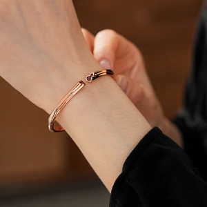 Close-up of rose gold open bangle with gourd design worn on a female wrist