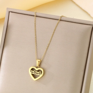 Détail du pendentif cœur en or 18 carats avec gravure mama dans un écrin à bijoux beige