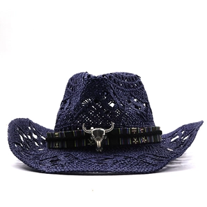 Close-up of hollow straw cowboy hat with ethnic ribbon and silver bull head ornament