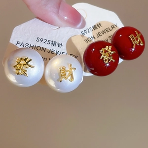 Gros plan de boucles d'oreilles en argent S925 rouges et perles avec caractères dorés