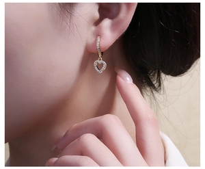 Detailed view of heart-shaped gold plated earring with micro-paved sparkling crystals