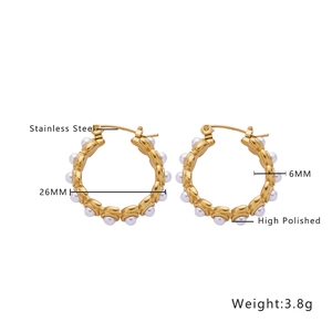 Macro view of 26mm high polished stainless steel gold hoop earrings with white pearls