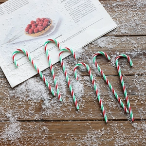 Set of 5 Christmas candy cane ornaments in red, white and green on wood background