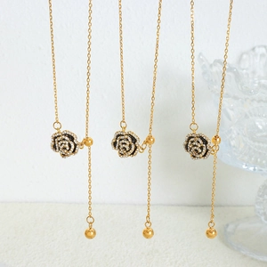 Elegant gold titanium steel necklace featuring black enamel roses and crystal tassels