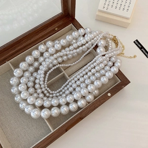 French vintage multi-layer pearl necklace with gold clasp on wooden jewelry box