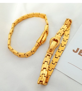 Macro detail of gold watchband-style bracelets with polished buckle design for women
