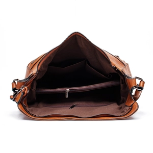 Detail view of the brown leather tote bag interior featuring multi-layer zip pockets