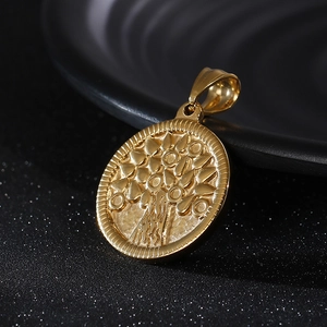 Macro shot of gold stainless steel Tree of Life pendant with embossed details