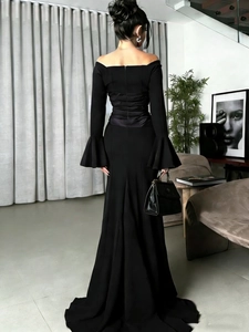 Detail of off-shoulder black formal gown with fitted waist and elegant flare sleeves
