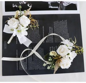 Detailed shot of white artificial wedding corsage and wrist flower with silk ribbons