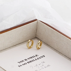 Macro shot of gold S925 sterling silver hoop earrings with diamonds in a jewelry box