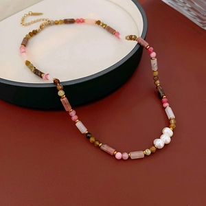 Detailed shot of bamboo-style pearl necklace with natural stones and gold-plated clasp